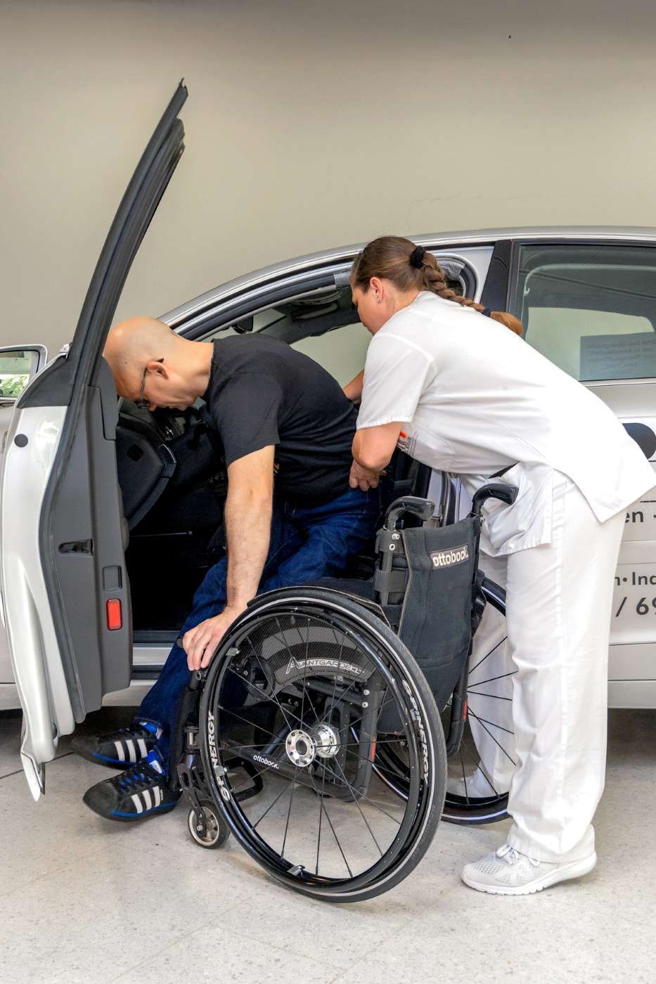 Querschnittpatient beim Einsteigen ins Auto