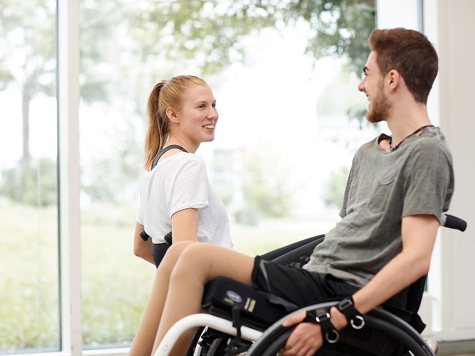 Konzernschwerbehindertenvertretung der BG Kliniken Frau und Mann im Rollstuhl im Gespräch