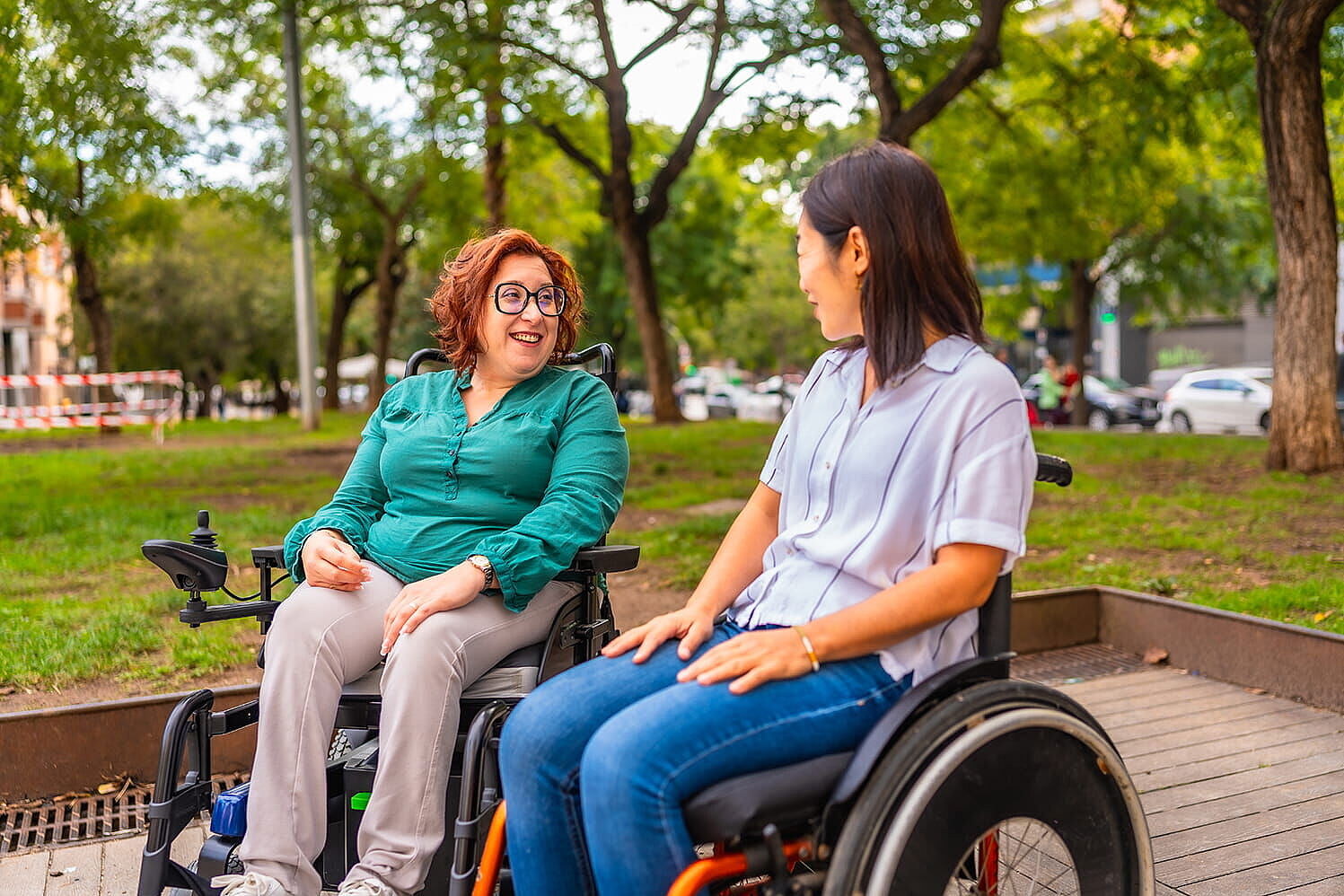 Peer-Beratung (iStock.com/Unaihuiziphotography) Zwei Frauen im Rollstuhl im Gespräch