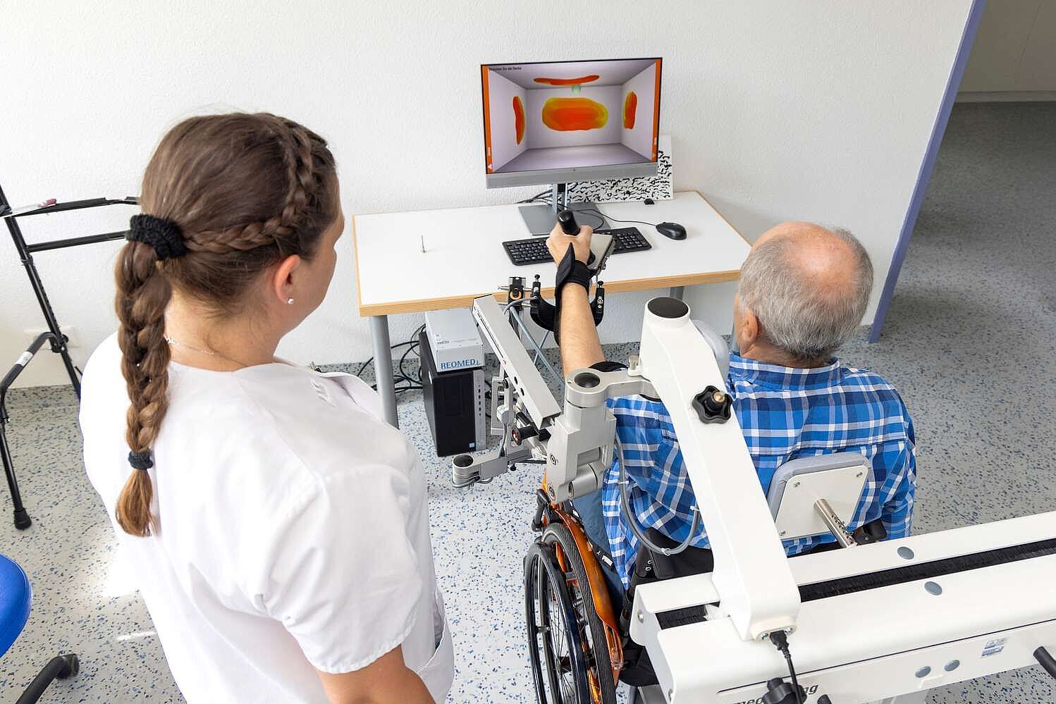 Ergotherapeutin mit Patient bei der digital unterstützten Therapie