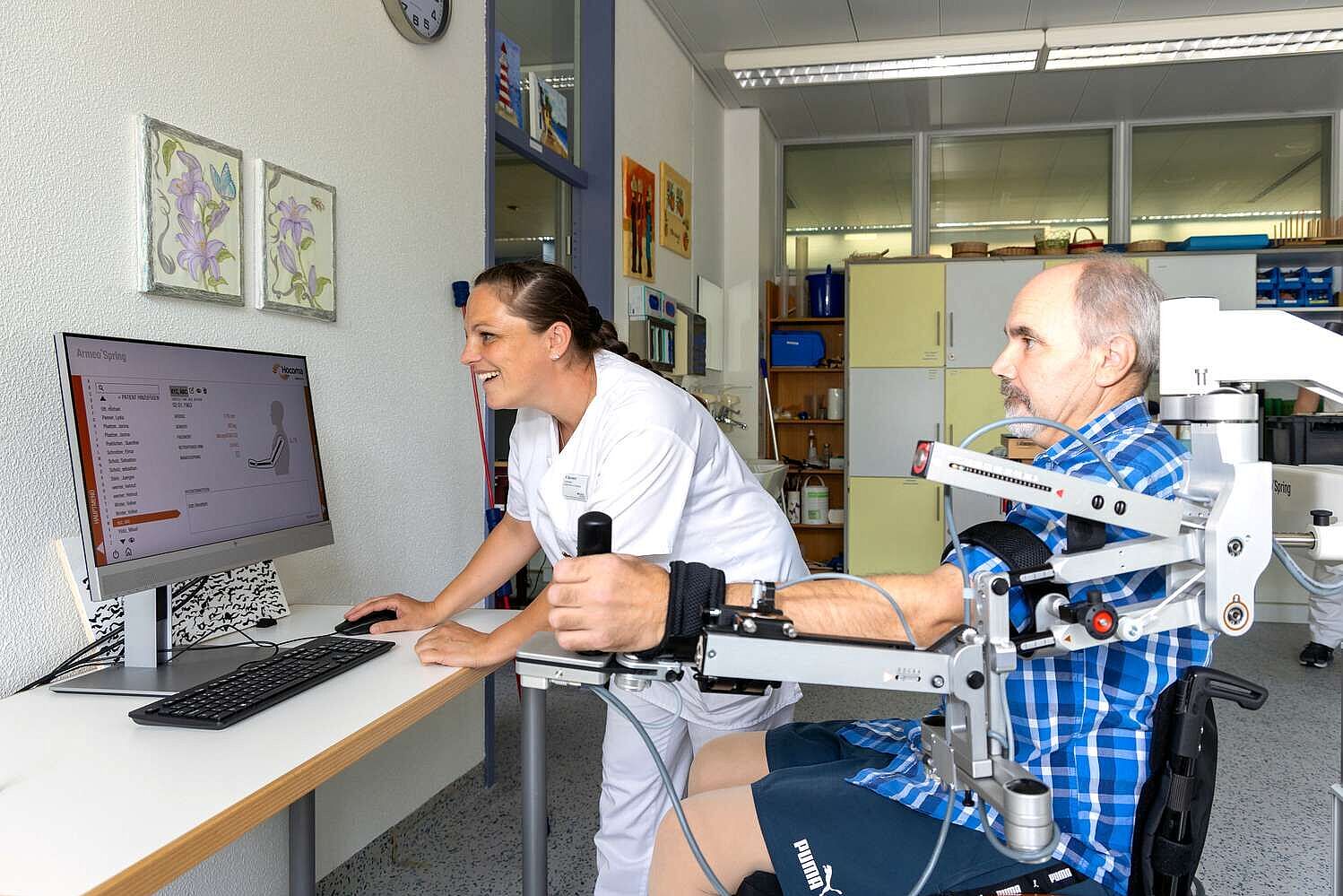 Ergotherapeutin mit Patient bei der digital unterstützten Therapie